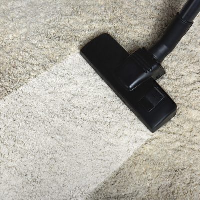 close-up view of cleaning white carpet with professional vacuum cleaner